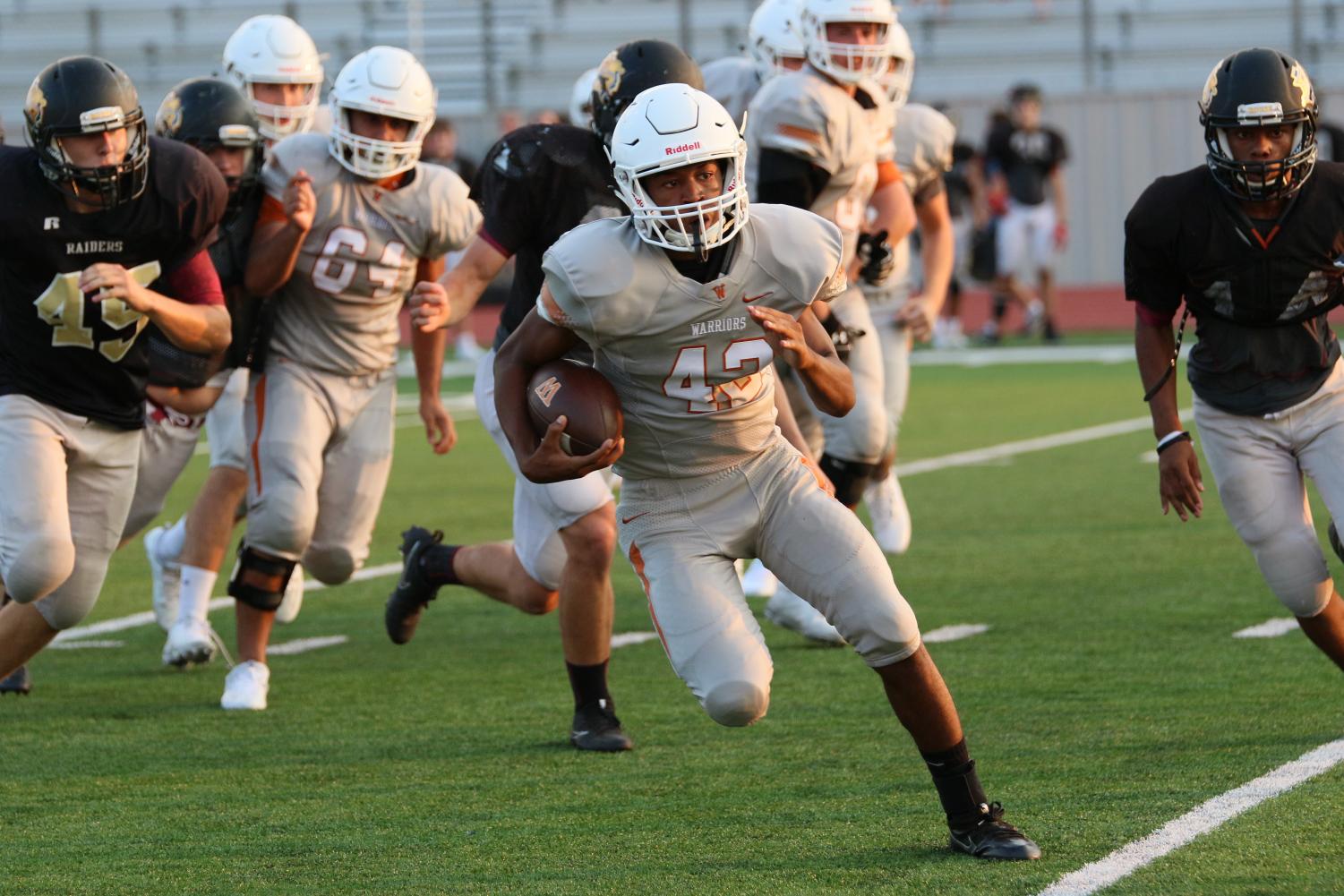 Varsity Football Faces Off Against Rouse Raiders In Scrimmage